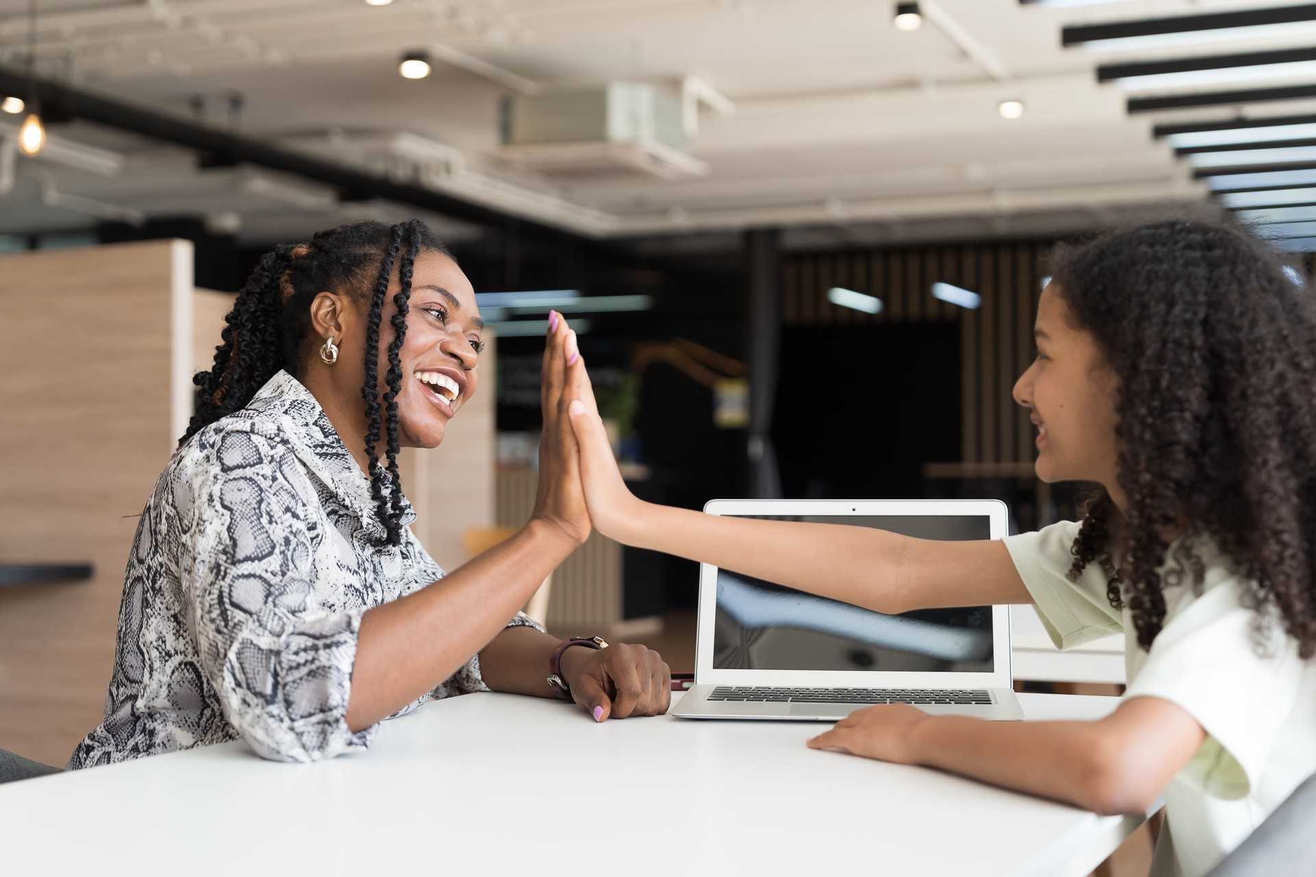 Female teacher teaching student using laptop computer in classroom. Student e-learning on laptop computer. Teacher assistance student using computer class in classroom