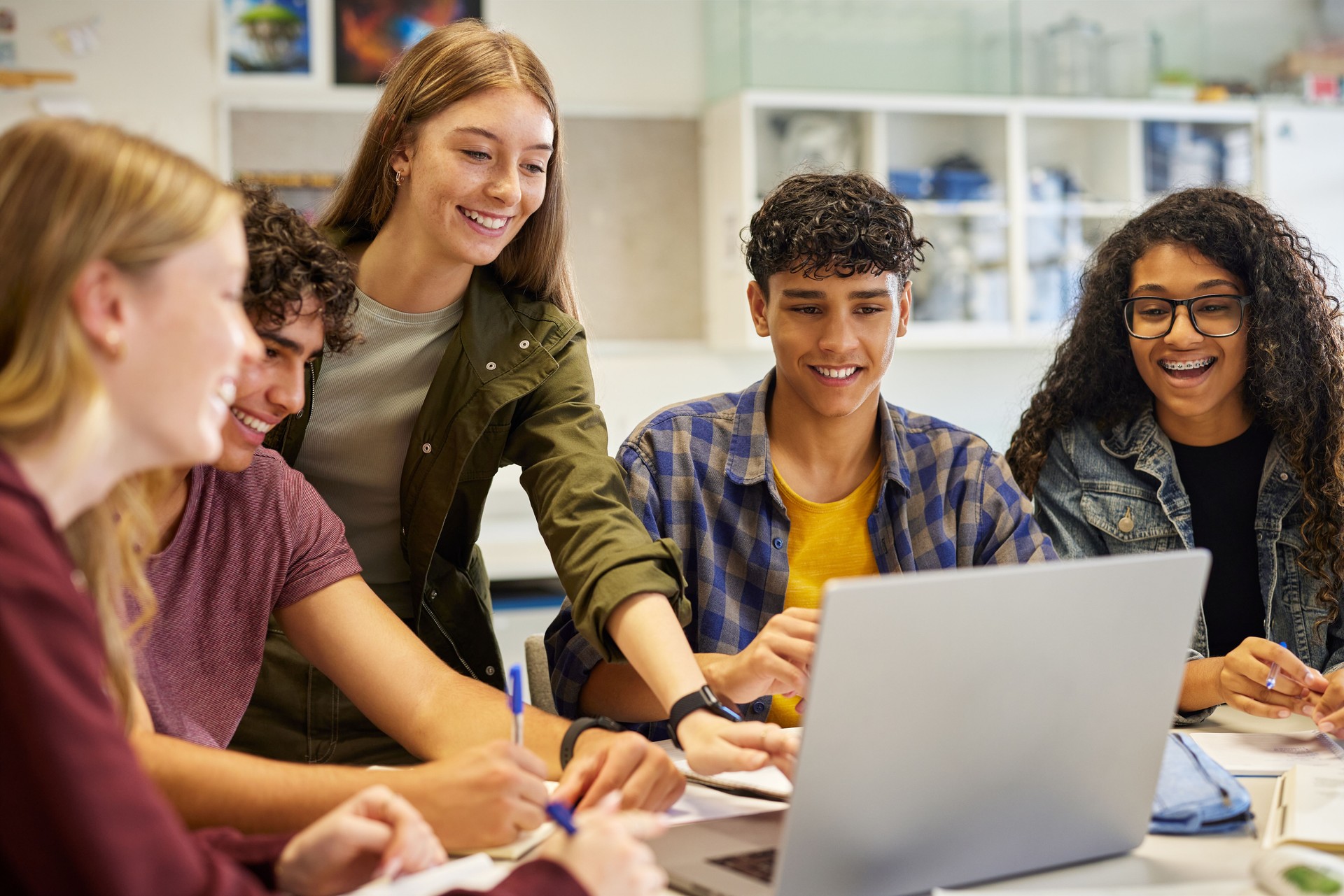 Happy smiling teens students studying in group
